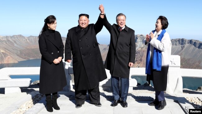 South Korean President Moon Jae-in and North Korean leader Kim Jong Un pose for photographs on the top of Mt. Paektu, North Korea, Sept. 20, 2018.