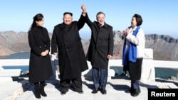 South Korean President Moon Jae-in and North Korean leader Kim Jong Un pose for photographs on the top of Mt. Paektu, North Korea, Sept. 20, 2018.