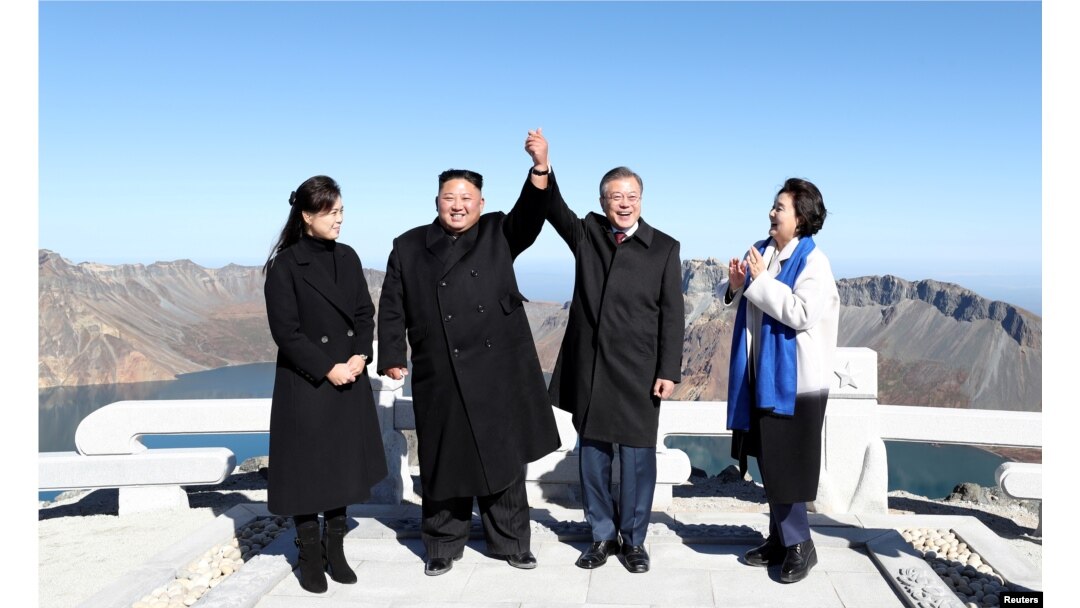 South Korean President Moon Jae-in and North Korean leader Kim Jong Un pose for photographs on the top of Mt. Paektu, North Korea, Sept. 20, 2018.