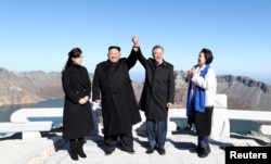 FILE - South Korean President Moon Jae-in and North Korean leader Kim Jong Un pose for photographs on the top of Mt. Paektu, North Korea, Sept. 20, 2018.