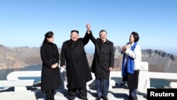 Presiden Korea Selatan Moon Jae-in berfoto bersama Pemimpin Korea Selatan, Kim Jong-un di puncak gunung Paektu, Korea Utara, 20 September 2018. 