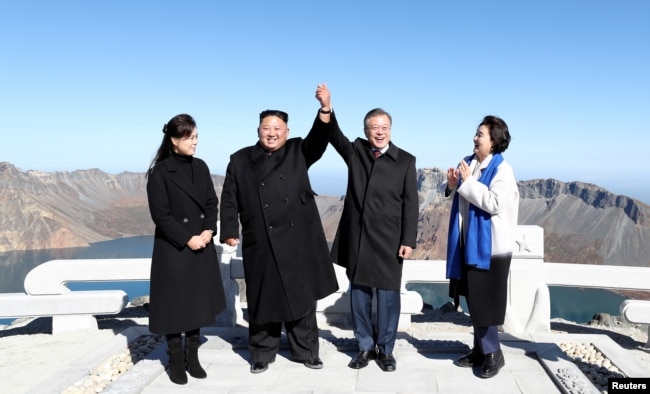 South Korean President Moon Jae-in and North Korean leader Kim Jong Un pose for photographs on the top of Mt. Paektu, North Korea, Sept. 20, 2018.