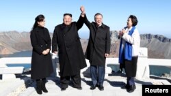 South Korean President Moon Jae-in and North Korean leader Kim Jong Un pose for photographs on the top of Mt. Paektu, North Korea, Sept. 20, 2018.