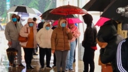 People wear face mask as they stand in line for a free COVID-19 test outside the Lincoln Park Recreation Center in Los Angeles, Dec. 30, 2021.