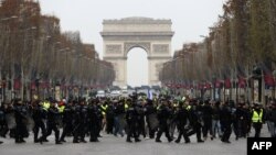 Polisi anti huru-hara Perancis menghadang para demonstran berjaket kuning (gilets jaunes) yang berunjuk rasa memprotes kenaikan harga BBM di Champs-Elysees, Paris, 15 Desember 2018. (Foto: dok).