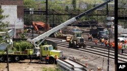 Para petugas tengah memperbaiki lokasi kecelakaan kereta Amtrak di Philadelphia (15/6).