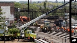 Workers labor at the site of Tuesday's derailment of an Amtrak Northeast Regional train in Philadelphia, May 15, 2015.