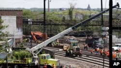 Workers labor at the site of Tuesday's derailment of an Amtrak Northeast Regional train in Philadelphia, May 15, 2015.
