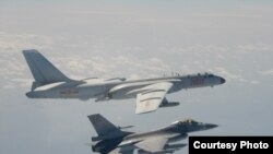 中國10日派遣多架戰機進行繞台遠航訓練，台灣F16戰機(下)伴飛監控中國轟六戰機。(台灣國防部提供) 