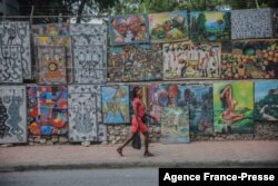 FILE - A woman walks in a deserted street in Port-au-Prince on Oct. 18, 2021.