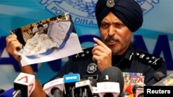 Commissioner Amar Singh, Malaysia's Federal Commercial Crime Investigation Department (CCID) director, displays a photo of items from a raid during a news conference in Kuala Lumpur, June 27, 2018. 