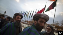 Members of the Loya Jirga, or grand assembly, prepare to leave after its closing ceremony in Kabul, November 19, 2011.