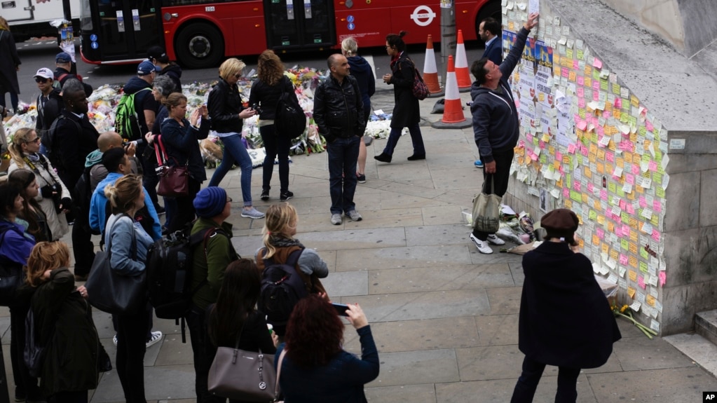 A man fixes a paper between other messages against Saturday's attack on a wall near the London Bridge in London, June 8, 2017. 