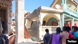 Ljudi stoje ispred srušene zgrade posle zemljotresa u mestu Džeremi na Haitiju, 14. avgusta 2021. TWITTER @JCOMHaiti/ via REUTERS