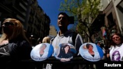 Un vendedor ofrece fotos de la presidenta Cristina Fernández, en las afueras del hospital donde estuvo internada.