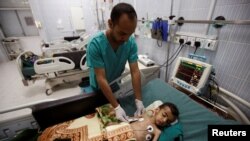 FILE - A nurse checks a boy at a hospital intensive care unit in Sanaa, Yemen, September 27, 2016.