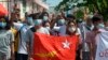 Anti-coup protesters hold the flag of the National League for Democracy party of ousted Myanmar leader Aung San Suu Kyi, while others flash the three-fingered salute during a 'flash mob' rally in Bahan township in Yangon, Myanmar, May 9.