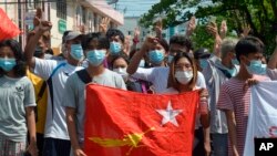 Anti-coup protesters hold the flag of the National League for Democracy party of ousted Myanmar leader Aung San Suu Kyi, while others flash the three-fingered salute during a 'flash mob' rally in Bahan township in Yangon, Myanmar, May 9.