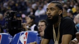 FILE - Rapper Nipsey Hussle watches an NBA basketball game between the Golden State Warriors and the Milwaukee Bucks, March 29, 2018, in Oakland, Calif.