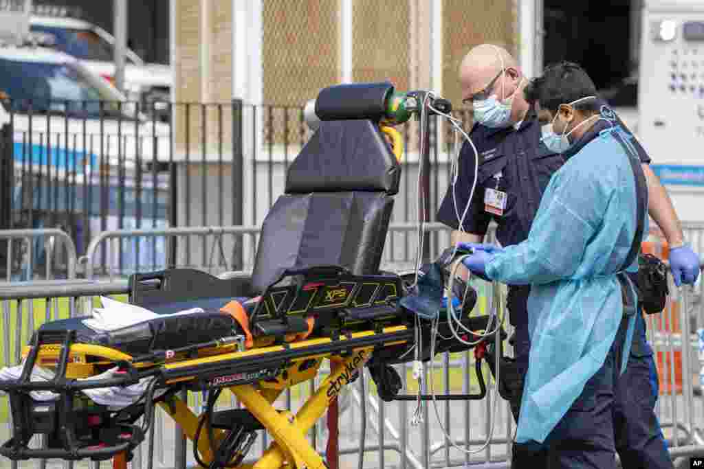 Personal de emergencia de salud desinfecta sus equipos después de llevar a un paciente al Centro Hospitalario Elmhurst, el sábado 4 de abril de 2020, en el distrito de Queens de Nueva York.