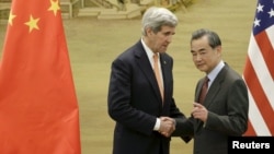 U.S. Secretary of State John Kerry, left, shakes hands with China's Foreign Minister Wang Yi after the met in Beijing earlier this year. Yi is to travel to the U.S. to discuss a number of issues.