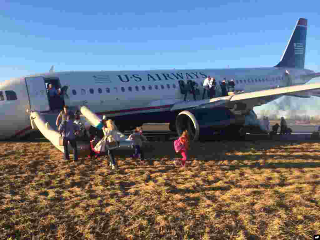Passengers evacuate U.S. Airways Flight 1702 after the pilot was forced to abort takeoff shortly after 6 p.m., after a tire on the front landing gear blew out in Philadelphia, Mar. 13, 2014. The Airbus A320 jet, bound for Fort Lauderdale, Florida, was carrying 149 passengers and five crew members, airport spokeswoman Victoria Lupica said.