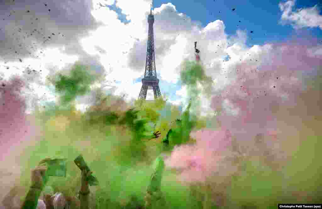 People covered in colourful chalk powder dance at the finish line during the Parisian edition of the 'Color Run' in Paris, France.