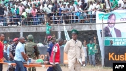 Une femme blessée lors d'une bousculade est emportée sur une civière lors de la cérémonie d’investiture du président de Sierra Leone Maada Bio à Freetown le 12 mai 2018.