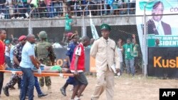 Une femme est emportée sur une civière lors de la cérémonie d’investiture du président de Sierra Leone Maada Bio à Freetown le 12 mai 2018. 