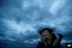 Russ Lewis covers his eyes from a gust of wind and a blast of sand as Hurricane Florence approaches Myrtle Beach, S.C., Sept. 14, 2018.