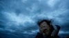 Russ Lewis covers his eyes from a gust of wind and a blast of sand as Hurricane Florence approaches Myrtle Beach, S.C., Sept. 14, 2018.