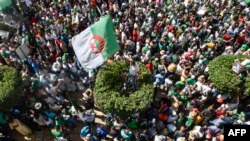 Des manifestants algériens scandent des slogans et brandissent des drapeaux nationaux dans les rues de la capitale, Alger, le 26e vendredi consécutif de manifestations du 16 aout 2019.