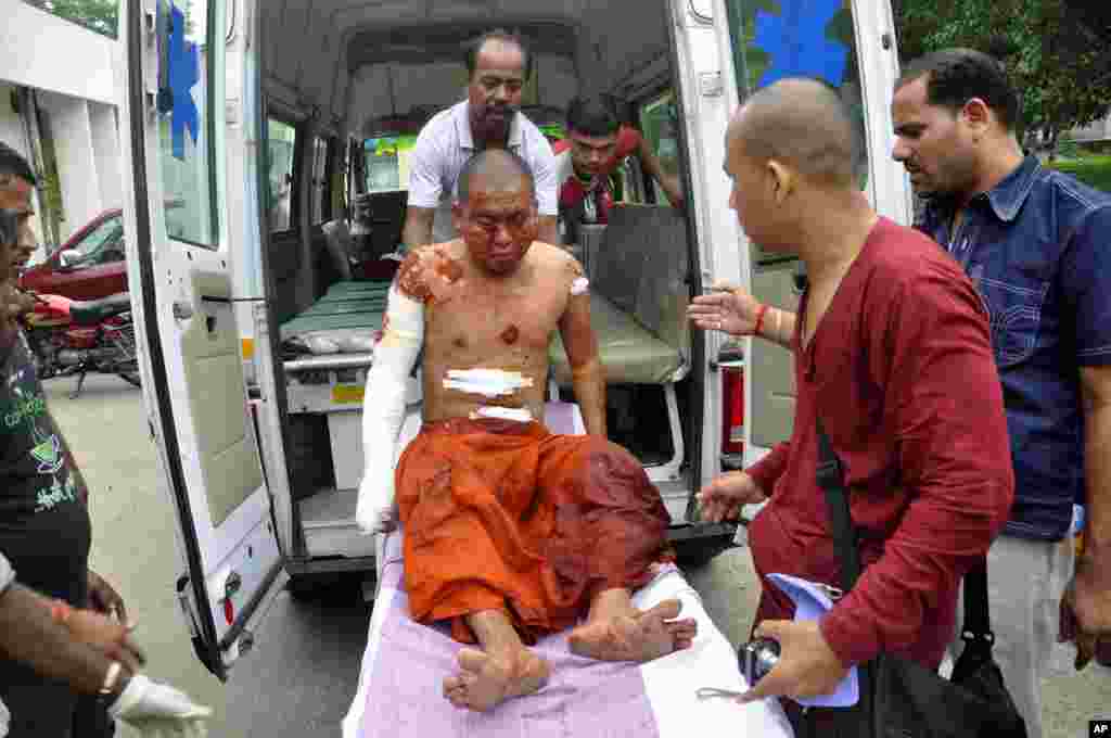 A Buddhist monk is carried on a stretcher for treatment after he was injured in an explosion in Bodh Gaya, Bihar, India, July 7, 2013. 