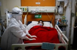A medical worker takes care of a patient with coronavirus disease, inside the Intensive Care Unit at the Government Institute of Medical Sciences hospital, in Greater Noida, on the outskirts of New Delhi, India, May 21, 2021.