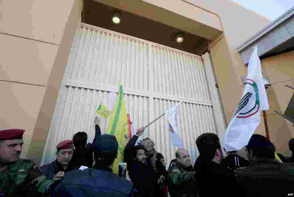 Miembros de las fuerzas de seguridad de Irak tratan de alejar a los manifestantes de la puerta de acceso a la embajada de Estados Unidos en Bagdad (Foto: Ahmad Al-Rubaye/AFP)