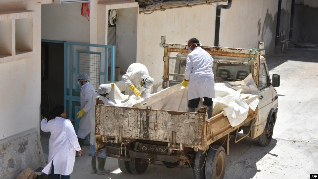 Para petugas medis dan forensik mengangkut mayat migran Afrika yang tenggelam di perairan Tunisia, di luar rumah sakit kota Gabes, Tunisia (17/7).