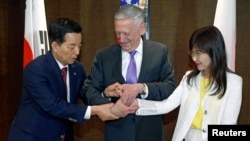 South Korea's Defense Minister Han Min-koo shows U.S. Secretary of Defense Jim Mattis and Japan's Defense Minister Tomomi Inada how to do a handshake during a trilateral meeting on the sidelines of the 16th IISS Shangri-La Dialogue in Singapore, June 3,