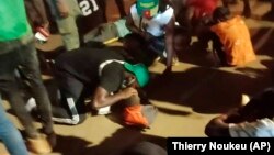 People assist victims of a stampede outside a stadium hosting an African Cup of Nations soccer game in Yaounde, Cameroon, Monday Jan. 24, 2022. Several people have died in a stampede that happened as crowds struggled to get access to Olembe Stadium to watch the host country