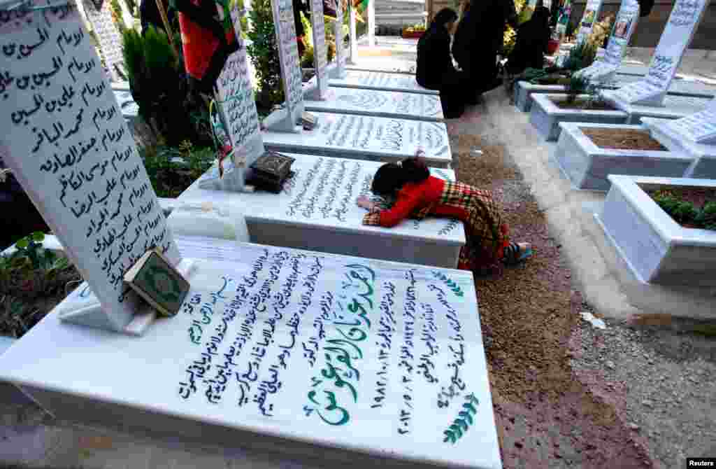 Relatives visit a grave at the Shi&#39;ite fighters cemetery in Damascus, May 28, 2013.