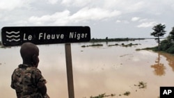 A Nigerois boy looking at the Niger River near Zinder. Aid agencies warn of a 'double disaster' for millions of people in Niger where heavy rains and flooding are compounding food shortages caused by a prolonged drought.