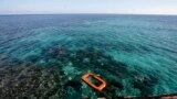 FILE - Philippine Marine, right, swims in the waters of Second Thomas Shoal in the South China Sea. 