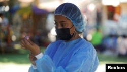 El trabajador de la salud prepara la dosis de una vacuna contra la enfermedad por coronavirus (COVID-19) en un centro de vacunación móvil en Panchimalco, El Salvador, el 5 de octubre de 2021.