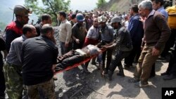 In this picture released by the Tasnim News Agency, miners and rescue personnel carry an injured mine worker after a coal mine explosion, near Azadshahr in northern Iran, May, 3, 2017. 