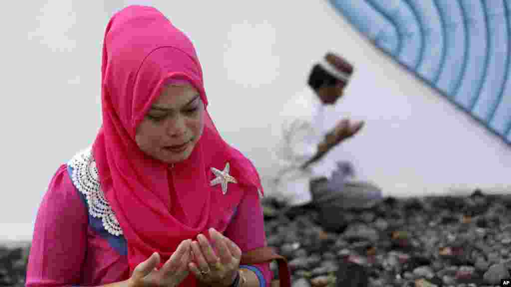 Une femme pleure victimes du tsunami en Asie Décembre 2004, priant devant une fosse commune dans Siron, Aceh Besar, l&#39;Indonésie, le 26 décembre 2014.