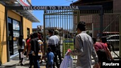 Archivo. Migrantes centroamericanos que regresaron de Estados Unidos a México bajo los Protocolos de Protección al Migrante (MPP), ingresan a un centro comercial en Tijuana, México, el 18 de julio de 2019.