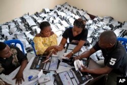FILE - Congolese independent electoral commission (CENI) officials count the presidential ballots from over 900 polling stations at a local results compilation center in Kinshasa, Jan. 4, 2019.
