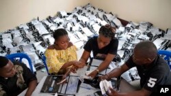 FILE - Congolese independent electoral commission (CENI) officials count the presidential ballots from over 900 polling stations at a local results compilation center in Kinshasa, Jan. 4, 2019.