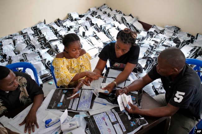 FILE - Congolese independent electoral commission (CENI) officials count the presidential ballots from over 900 polling stations at a local results compilation center in Kinshasa, Jan. 4, 2019.