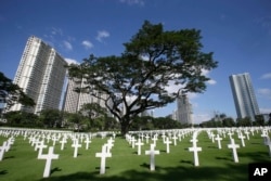Rows of crosses totaling 16,933 Latin crosses, 164 Stars of David and 3,740 unknowns, dot the 152-acre American Cemetery as U.S. and Filipino WWII veterans and other officials (unseen) commemorate U.S. Veterans Day at the American Cemetery at suburban Taguig city, east of Manila, Philippines, Nov. 11, 2012.