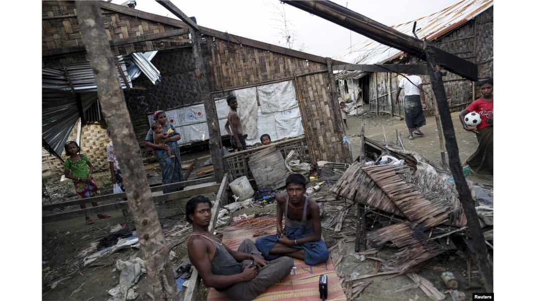 FILE - Rohingya people pass their time in a damaged shelter in Rohingya IDP camp outside Sittwe, Rakhine state, Myanmar.